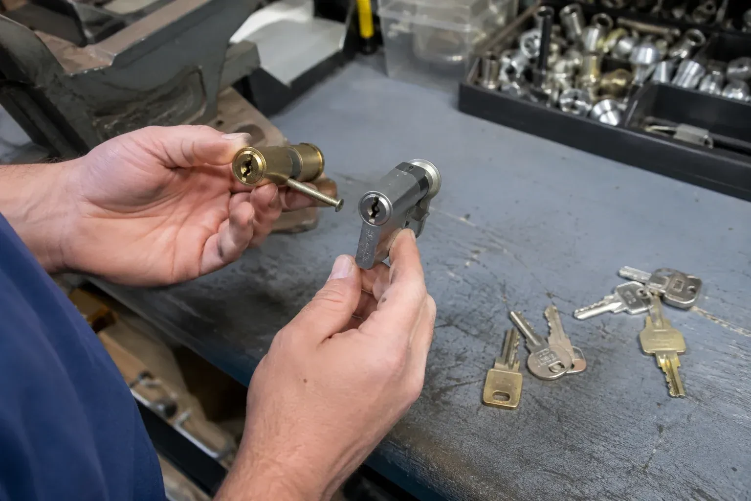 Hands comparing detached lock cylinders beside loose keys on a workbench. — Broken Key Extraction, Clarington